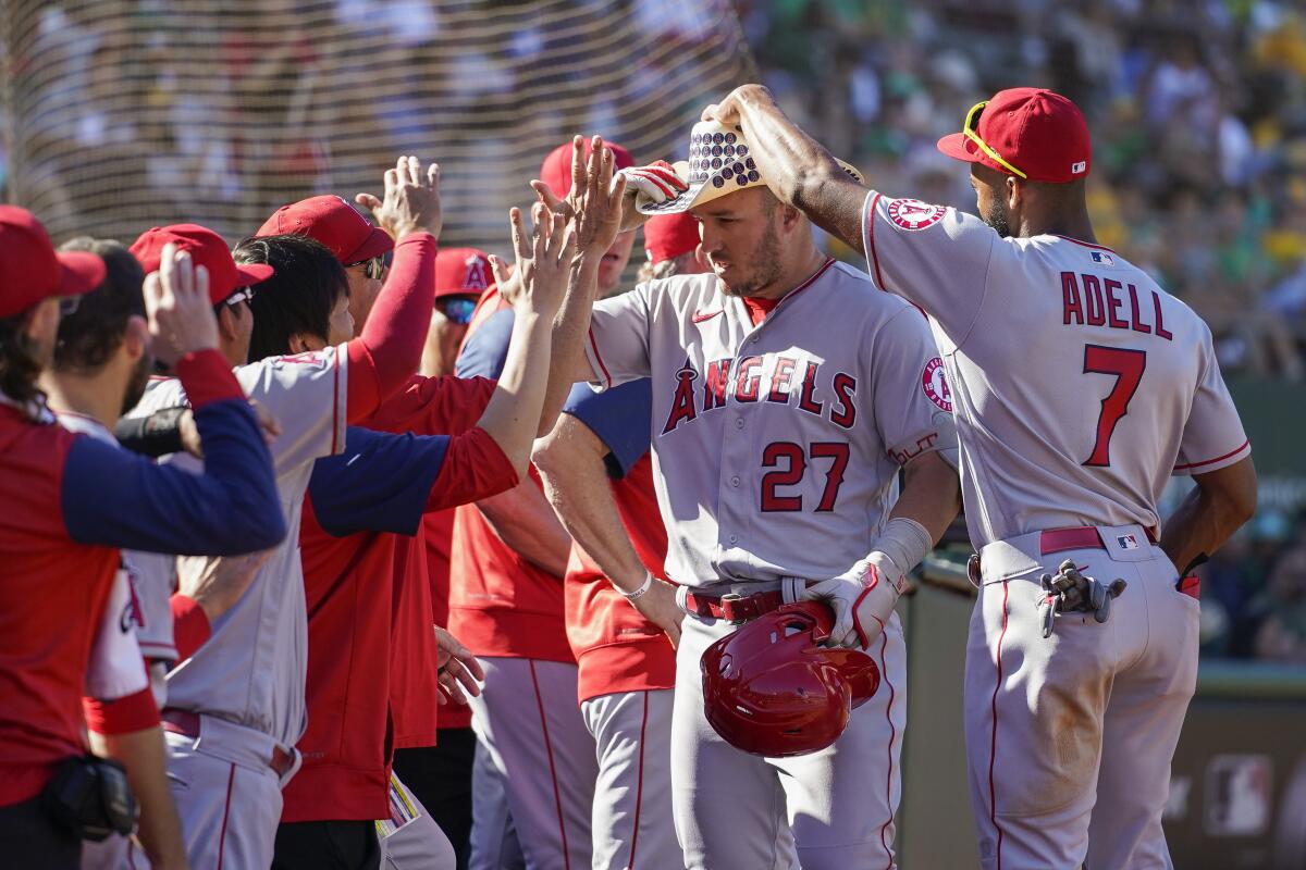 Angels' Jo Adell places a cowboy hat on Mike Trout, who had hit a solo home run against the Oakland Athletics.