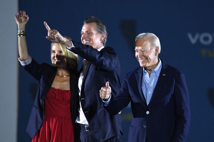 Long Beach, CA - September 13: U.S. US President Joe Biden (L) waves onstage with California Governor Gavin Newsom and his wife Jennifer Siebel Newsom during a campaign event at Long Beach City Collage, on Monday, Sept. 13, 2021 in Long Beach, CA. (Wally Skalij / Los Angeles Times)