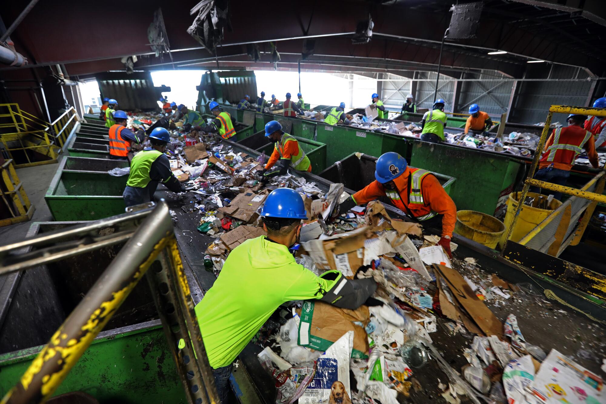 Workers separate recyclables at a plant.