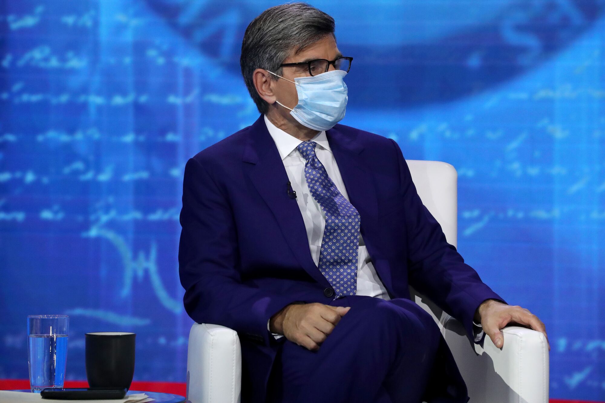 George Stephanopoulos in a mask on stage