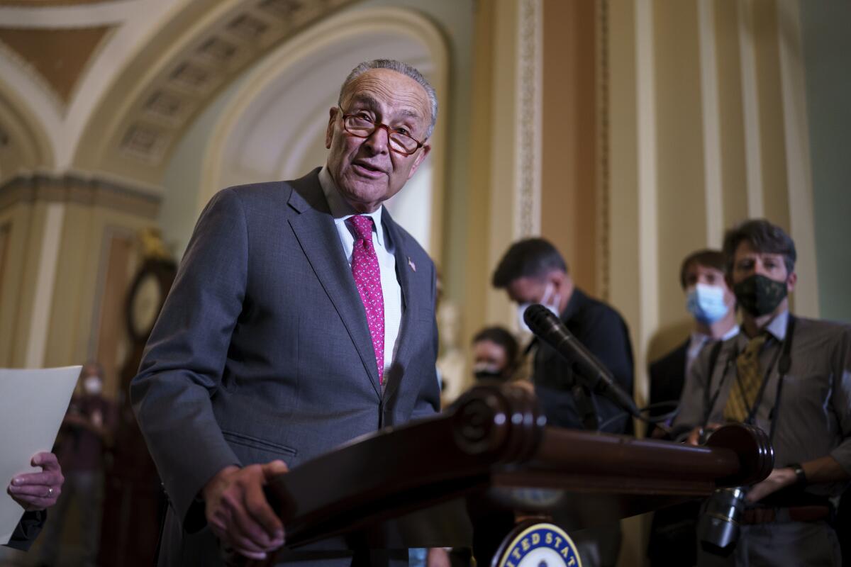 Charles E. Schumer speaks at a lectern to reporters