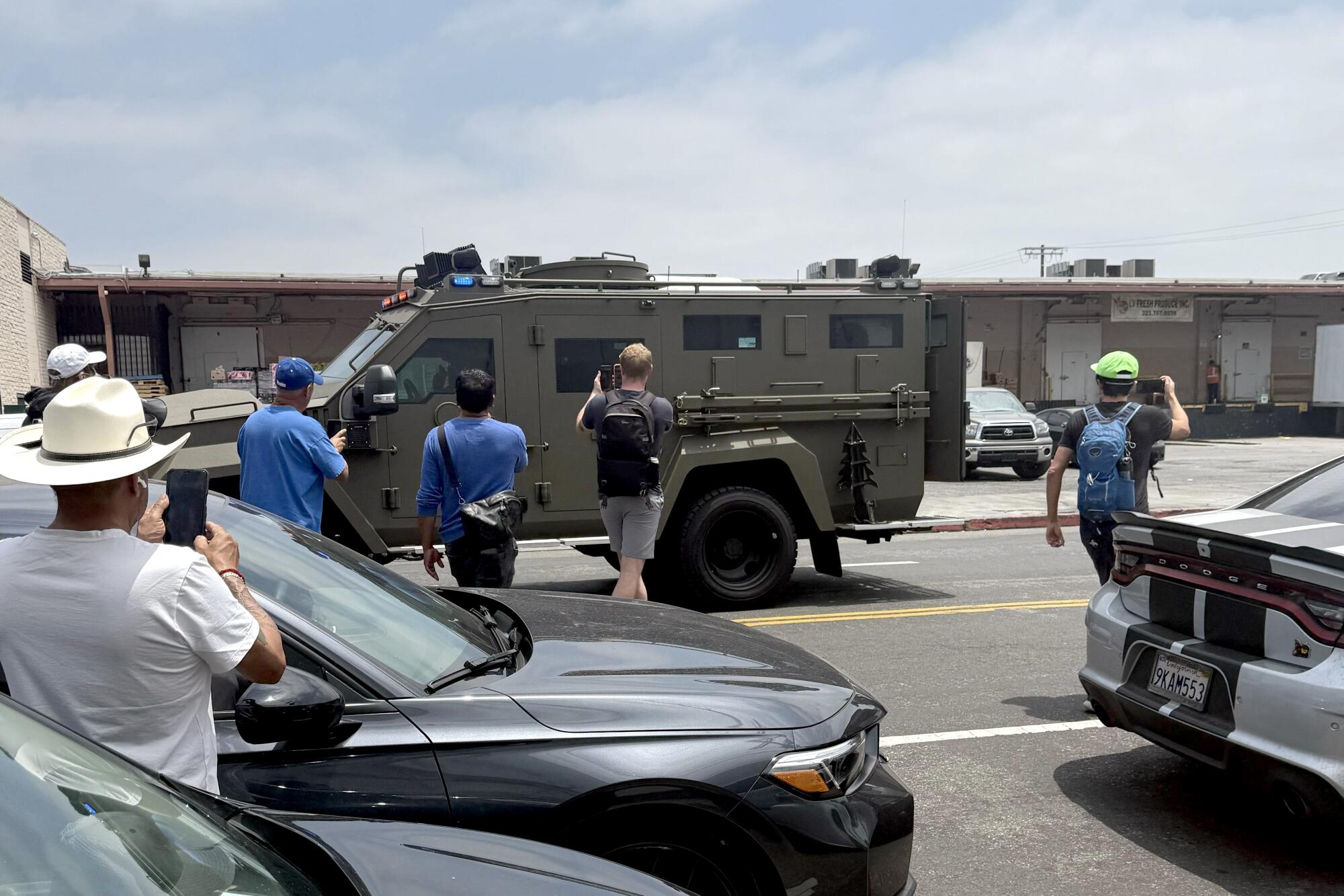 Protesters film federal agents as they leave the scene of an immigration raid Los Angeles on June 6.