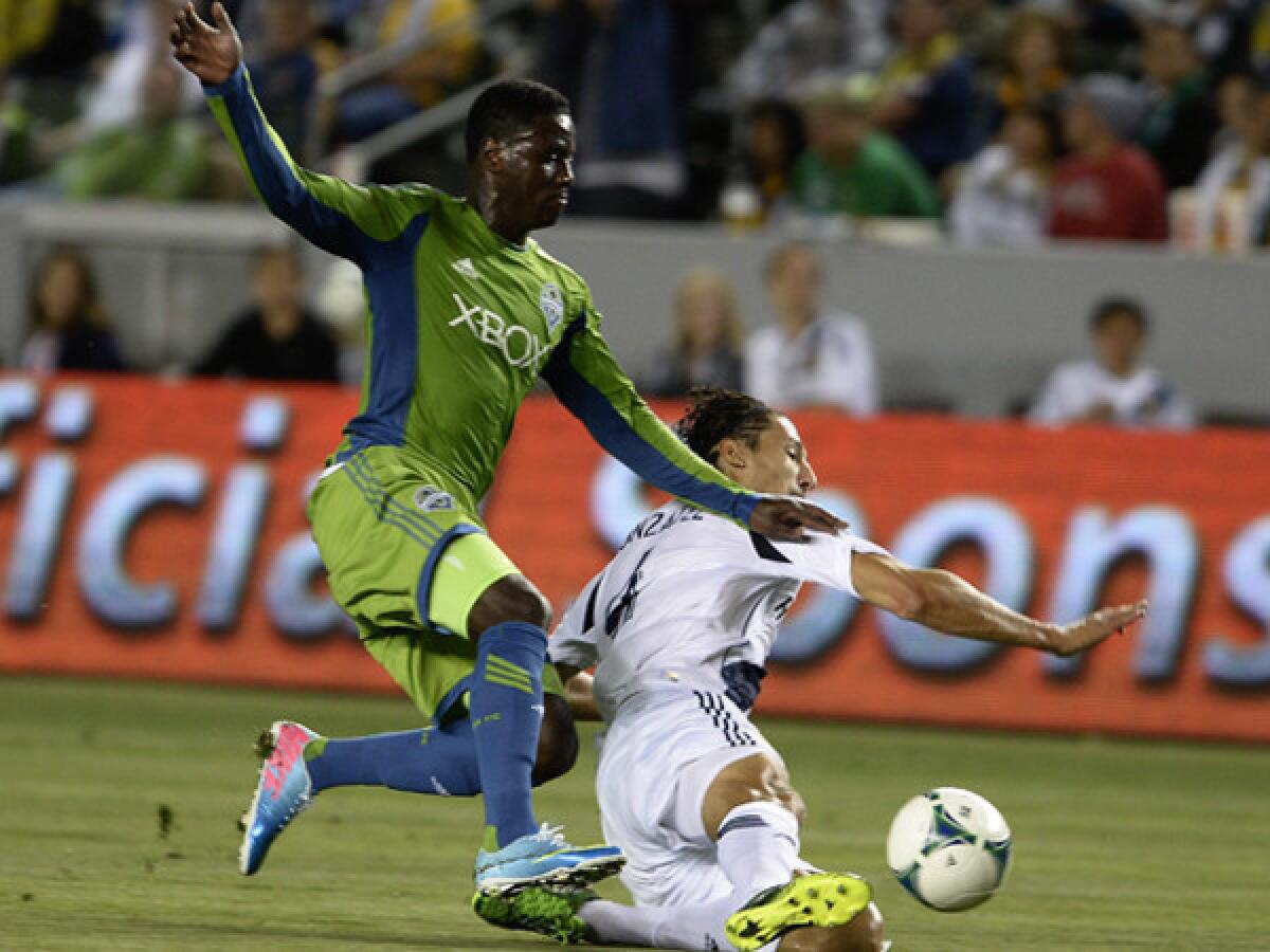 Galaxy's Omar Gonzalez, right, takes on Seattle's Eddie Johnson last week in a game in which the Galaxy matched its season high for goals (4).