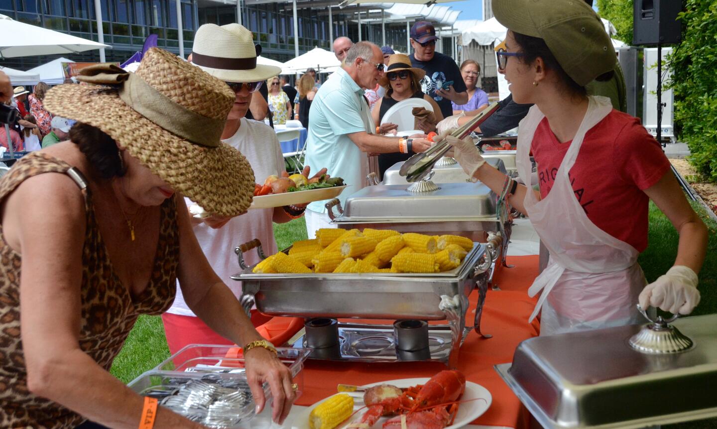 Guests line up for lobster, steak, potatoes, corn on the cob, rolls and salad during Lobsterfest on Sunday at the Newport Beach Civic Center.