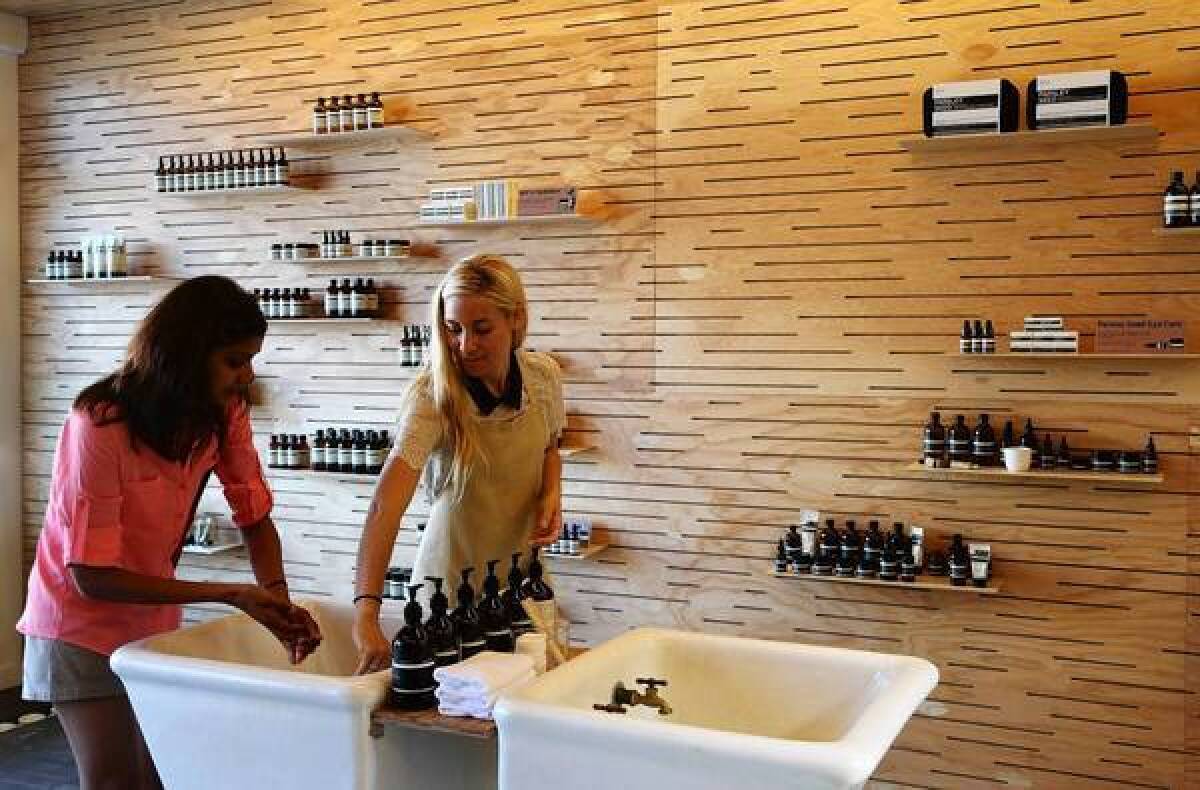 Customer Purva Merchang, left, tests a product with Aesop consultant Rachael Rendon in L.A.
