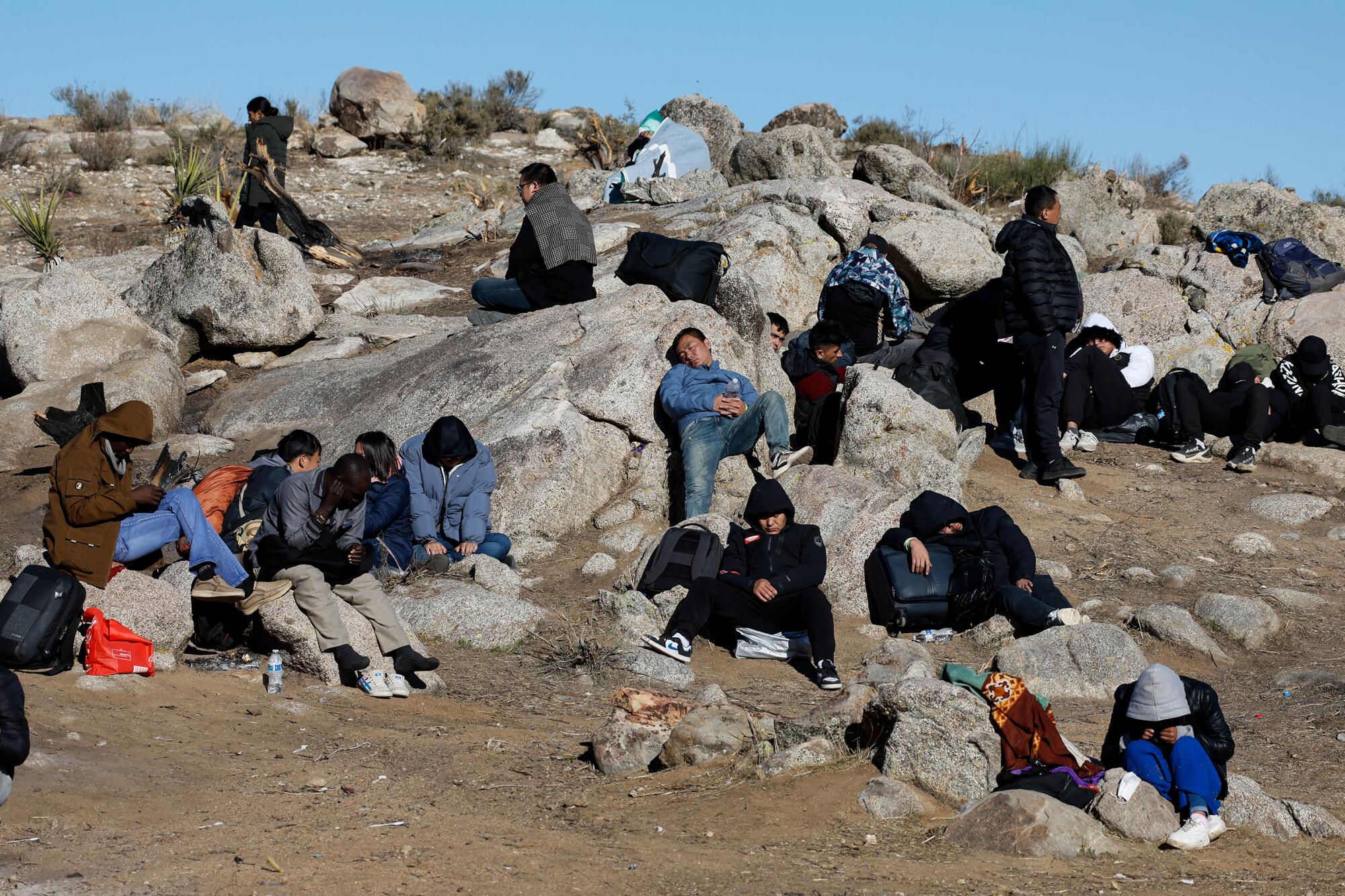 Migrants sleep on rocks. 