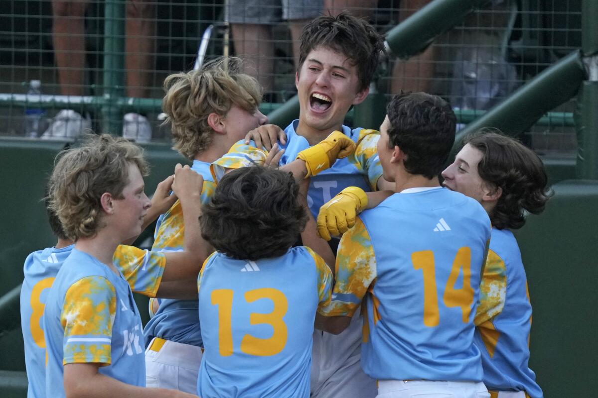 El Segundo, Calif.'s Louis Lappe, center, celebrates with teammates after hitting a solo walk-off home run.