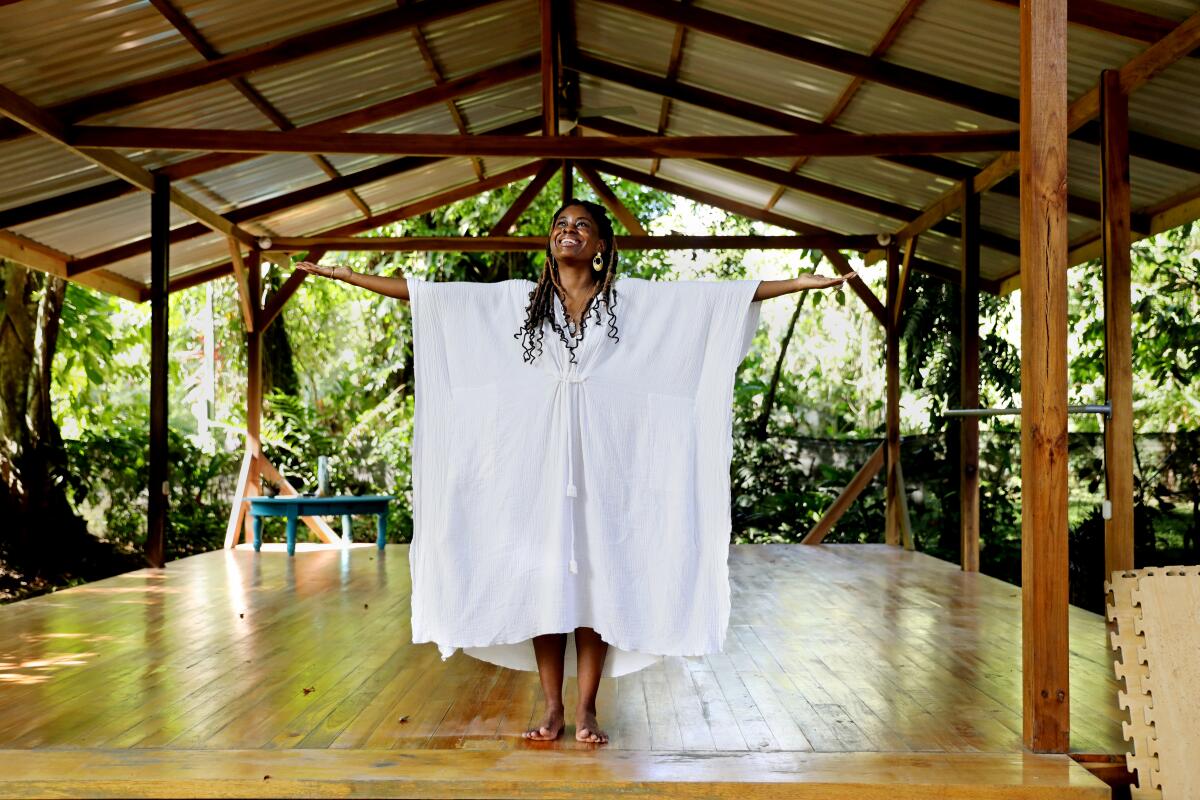 A woman poses for a photo in an outdoor yoga space