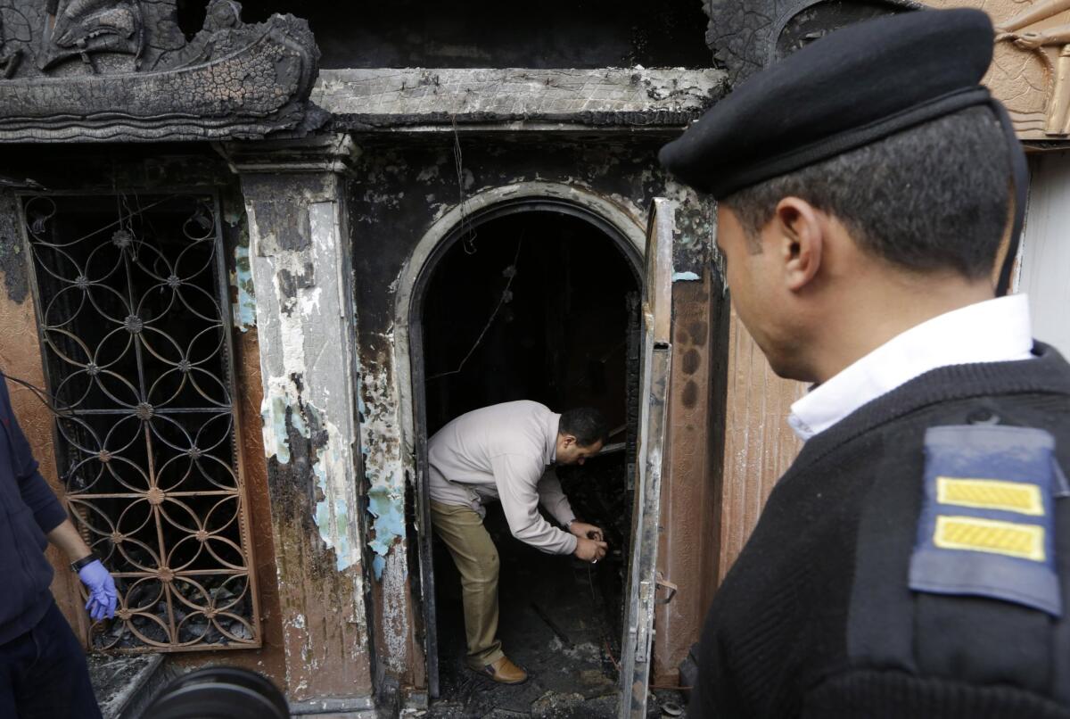 An Egyptian forensic member checks the gate of the Cairo nightclub that was fire-bombed early Friday.