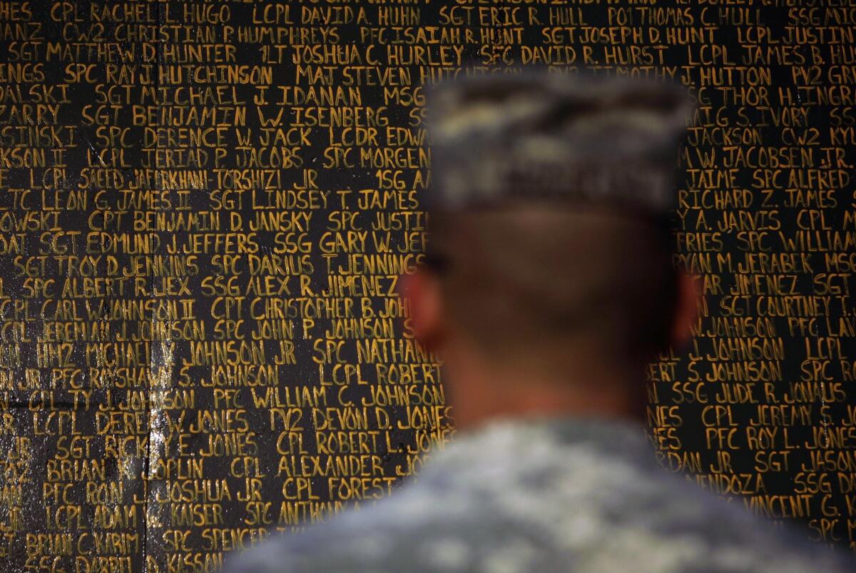 A soldier stands in front of a monument bearing the names of U.S. service members killed in Iraq since the 2003 U.S. invasion, at Forward Operating Base Warrior in Kirkuk in 2010.