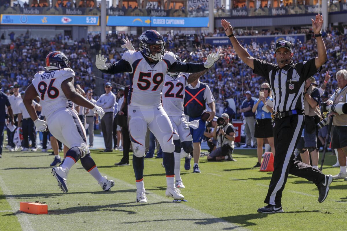 The Broncos' Malik Reed, 59,  looks to the official for a ruling after it appeared as if Chargers running back Austin Ekeler had fumbled at the one-yard line.