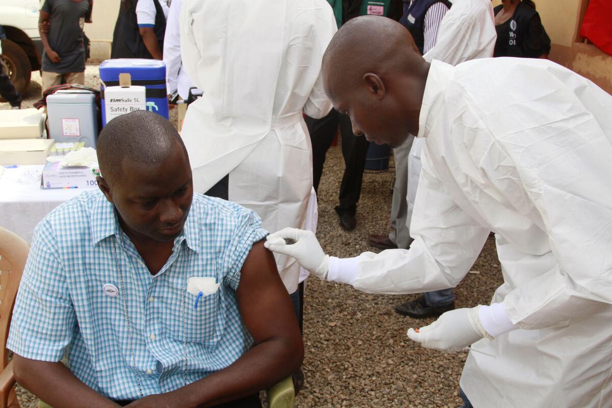 En fotografía del 7 de marzo de 2015 un trabajador de salud aplicará una vacuna experimental contra ébola a un hombre en Conakry, Guinea. La inmunización probada en miles de personas en Guinea parece ser efectiva de acuerdo con un erstudio publicado el viernes 31 de julio de 2015. (Foto AP/ Youssouf Bah, archivo)