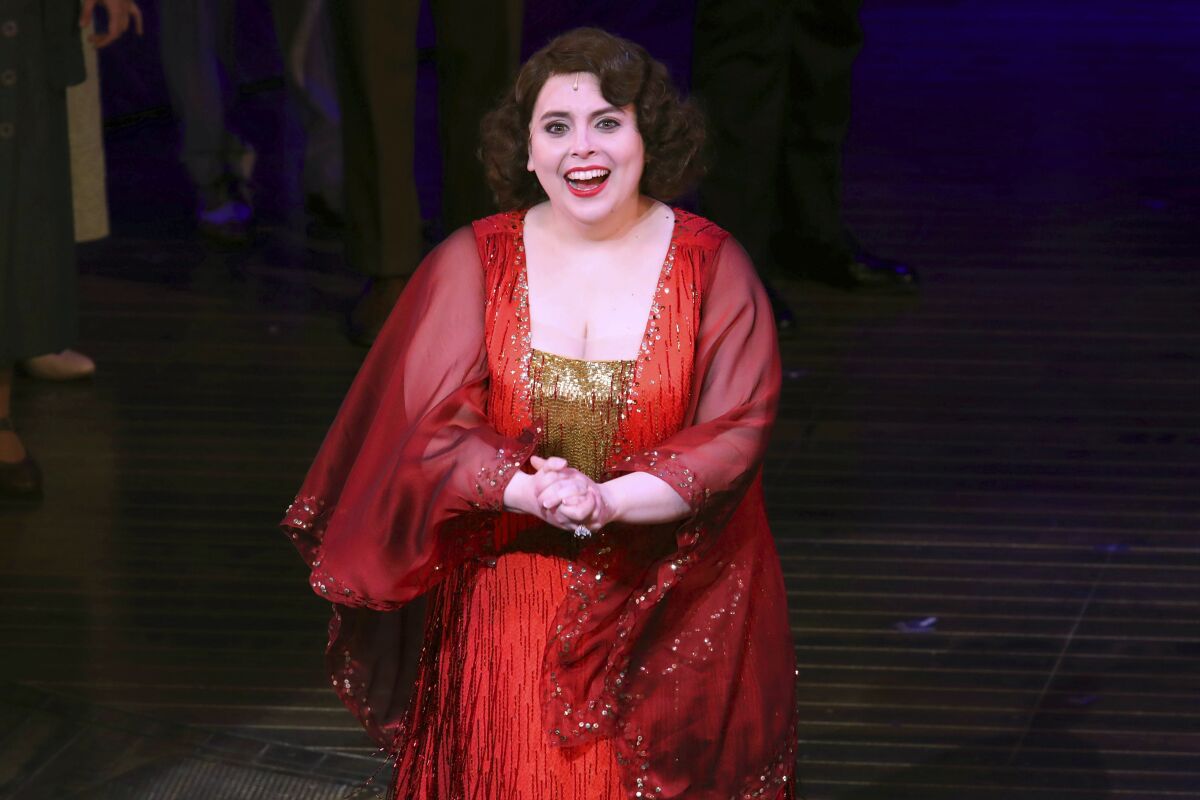 A woman wearing a red and gold dress on a stage