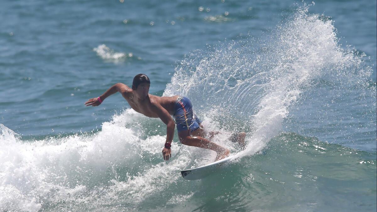 Defending champion Kanoa Igarashi goes backside off the top of a wave while warming up at the U.S. Open of Surfing in Huntington Beach on Wednesday.