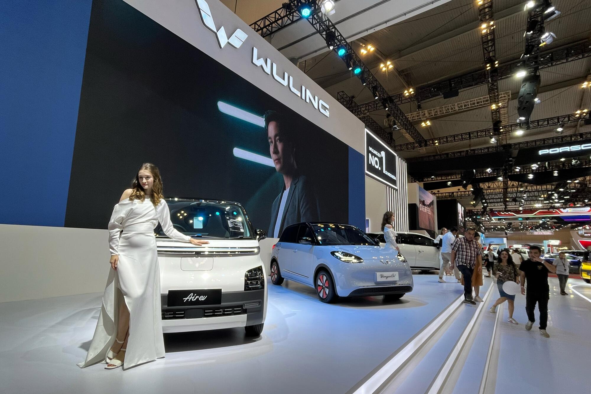 Vehicles are displayed onstage at an auto convention