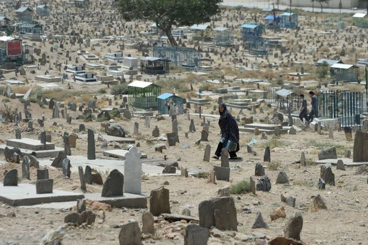 A woman walks in a cemetery in Kabul, Afghanistan. Civilian casualties in the Afghan war rose 23% in the first half of this year, the United Nations reported.