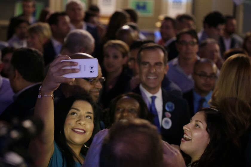 Sandra Lopez smiles for a selfie with Mayor Eric Garcetti during the Measure M party Tuesday night in downtown Los Angeles.