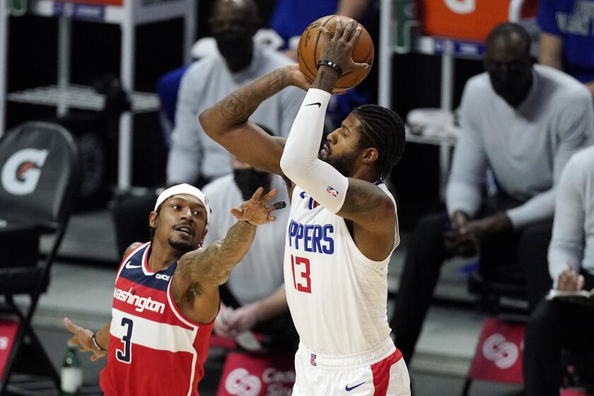 Los Angeles Clippers guard Paul George, right, shoots as Washington Wizards guard Bradley Beal defends during the first half of an NBA basketball game Tuesday, Feb. 23, 2021, in Los Angeles. (AP Photo/Mark J. Terrill)