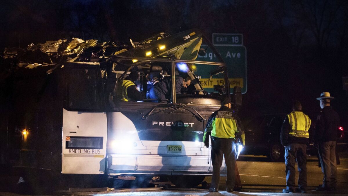 A bus that was carrying teenage passengers sits on the side of a highway after it hit an overpass on the Southern State Parkway in Lakeview, N.Y.