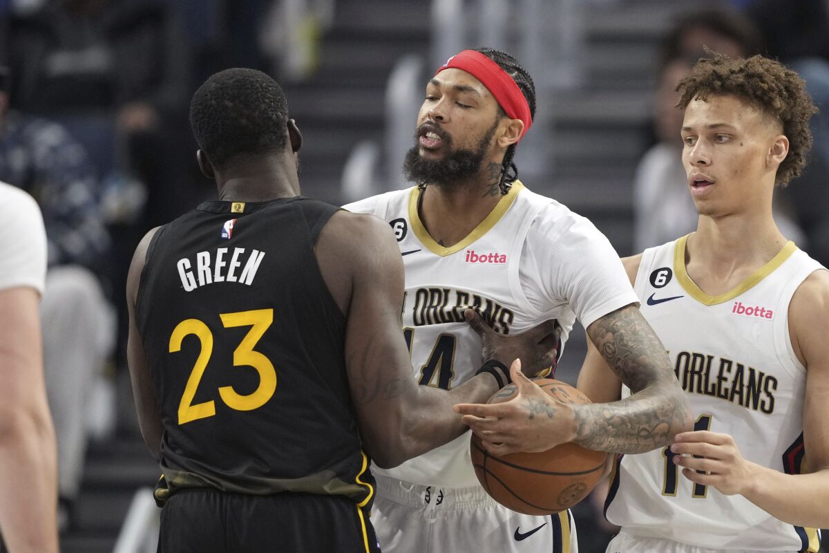 Golden State Warriors forward Draymond Green (23) and New Orleans Pelicans forward Brandon Ingram, center, confront each other as guard Dyson Daniels (11) looks on during the second quarter of an NBA basketball game Tuesday, March 28, 2023, in San Francisco. (AP Photo/Darren Yamashita)