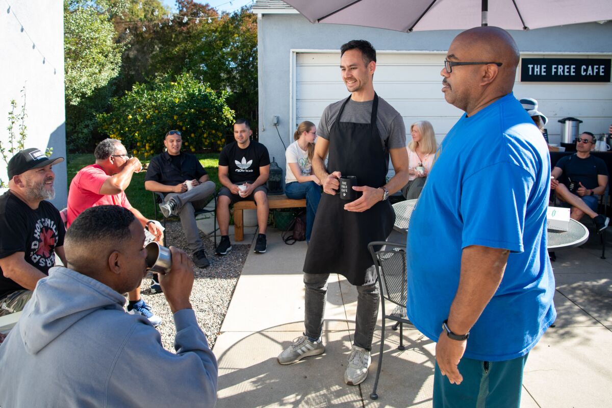 Michael Rippens, left, talks to neighbors at the Free Cafe, a monthly gathering held in his Leimert Park backyard.