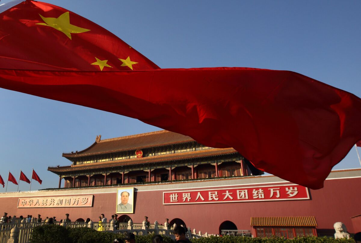 Una bandera china ondea frente a la Puerta de Tiananmen, en Beijing.