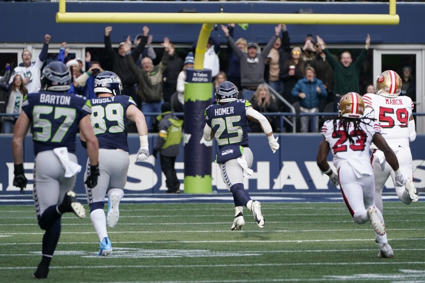 Seattle Seahawks running back Travis Homer (25) runs for a touchdown against the San Francisco 49ers during the first half of an NFL football game, Sunday, Dec. 5, 2021, in Seattle. (AP Photo/Elaine Thompson)