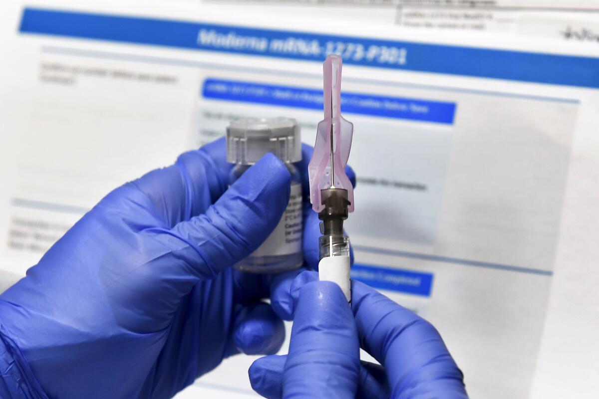 Una enfermera prepara una inyección como parte de un estudio de una posible vacuna contra el COVID-19 