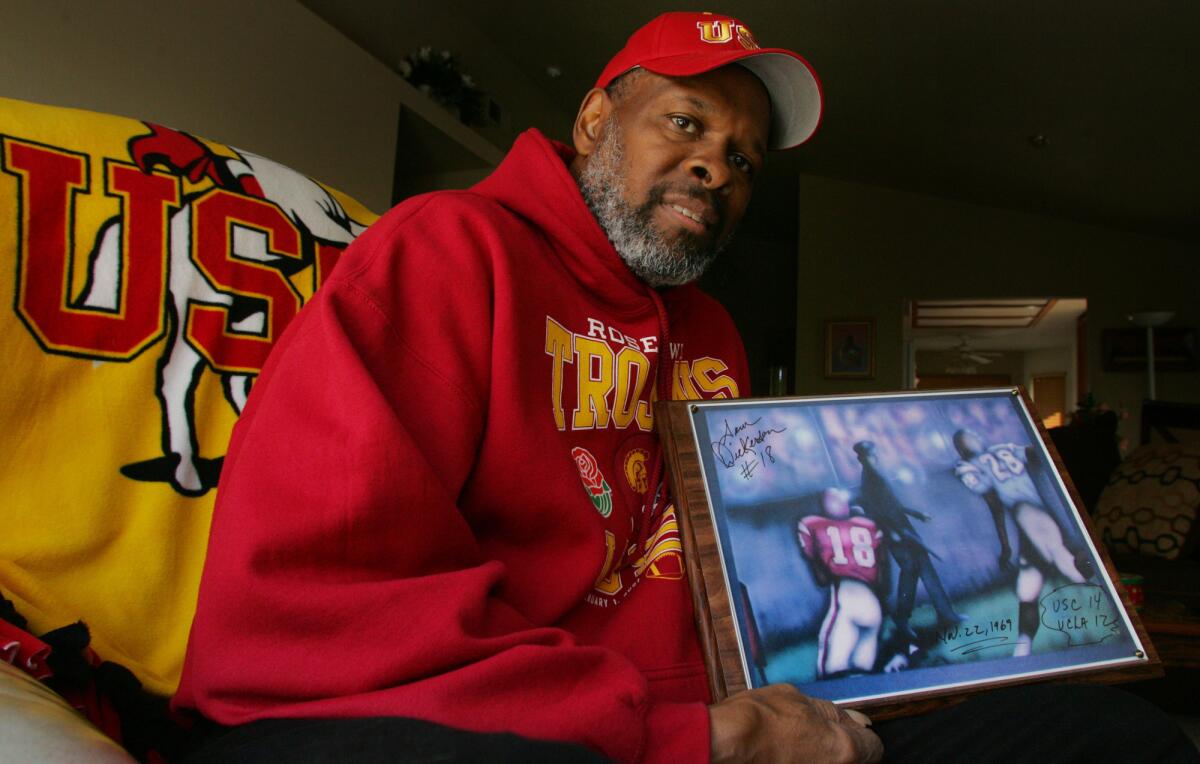Sam Dickerson is shown in 2009 holding artwork depicting the 1969 catch for which he is famous.