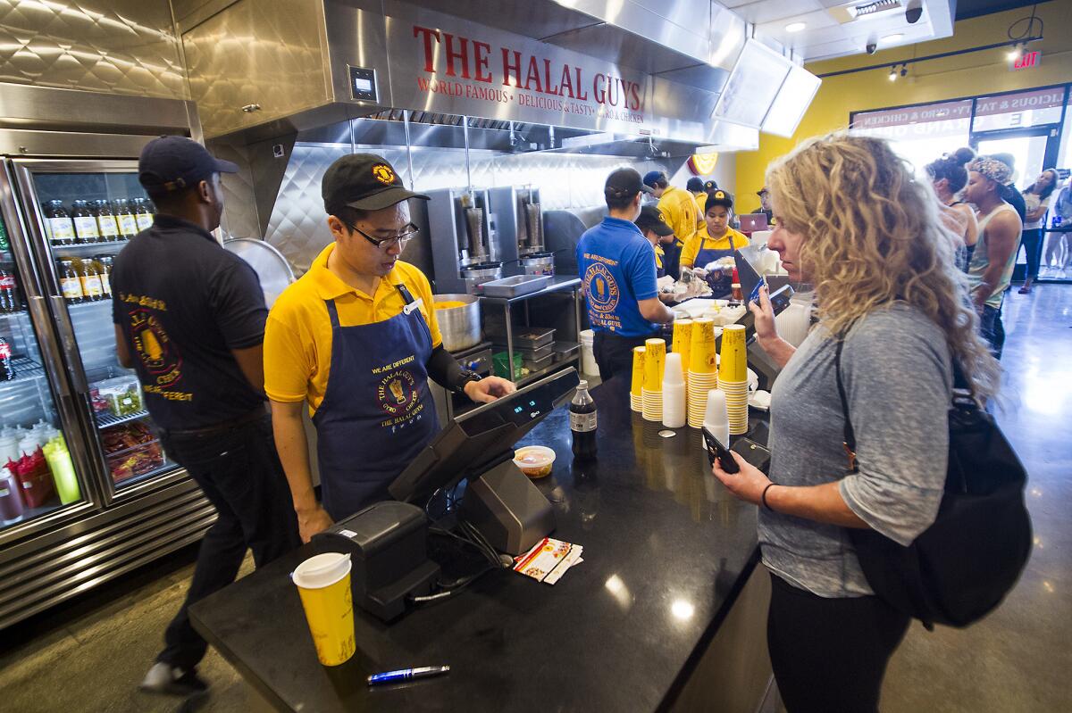 Shon Nguyen helps Lisa Kaplan during lunch at The Halal Guys in Costa Mesa.