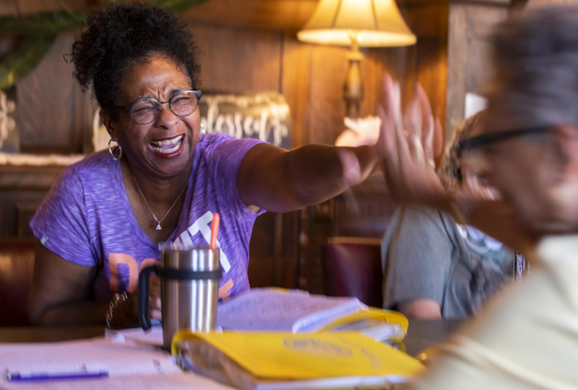 Maria Tirado, left, high fives Erica Byrd at a meeting of the support group