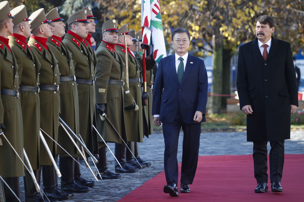 South Korea President Moon Jae-in, left, walks with Hungarian President Janos Ader while reviewing a honor guard during a welcoming ceremony in Budapest, Hungary, Wednesday, Nov. 3, 2021. (AP Photo/Laszlo Balogh)