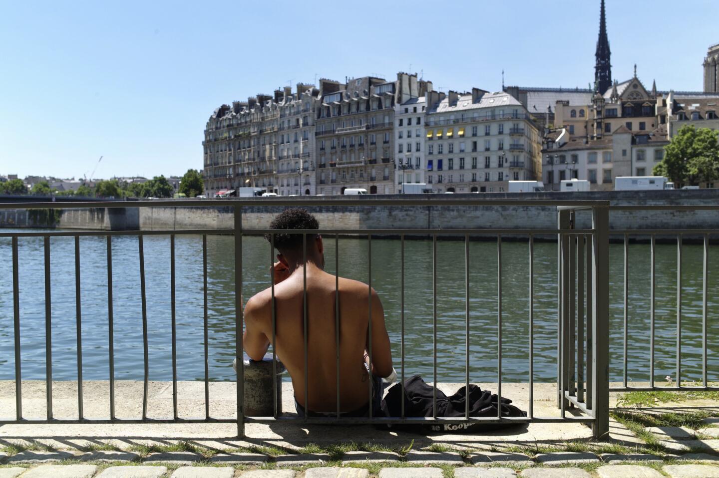 Un hombre trata de refrescarse junto al río en medio de una ola de calor en París.