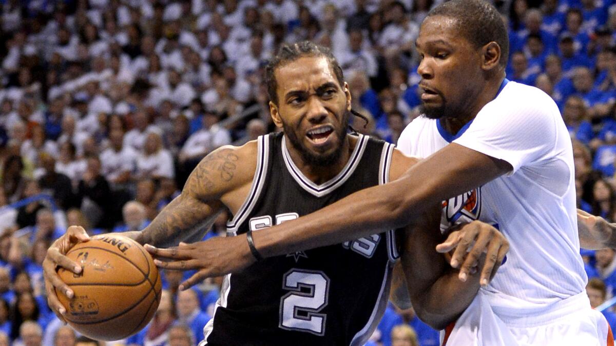 Spurs forward Kawhi Leonard (2) tries to drive against the long reach of Thunder forward Kevin Durant during the first half Friday.