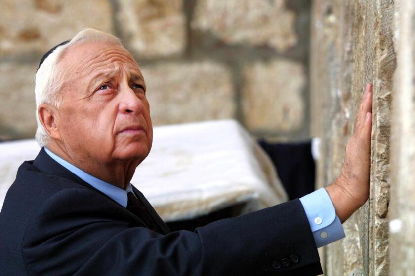 Israeli Prime Minister-elect Ariel Sharon places his hand on the Western Wall, Judaism's holiest site, in the Old City of Jerusalem in February 2001. It was Sharon's first public appearance the day after his landslide victory over incumbent Ehud Barak.
