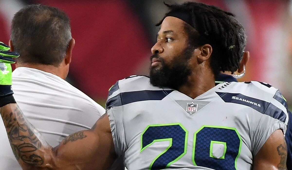 Seattle's Earl Thomas gestures in the direction of the Seahawks bench as he leaves the field on a cart.
