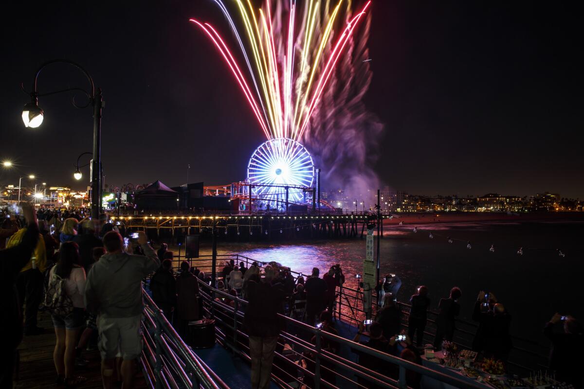 Fireworks are set off as people gather to celebrate "Lights On, " an event marking it's 20th birthday celebration of Santa Monica Pier's Pacific Park.