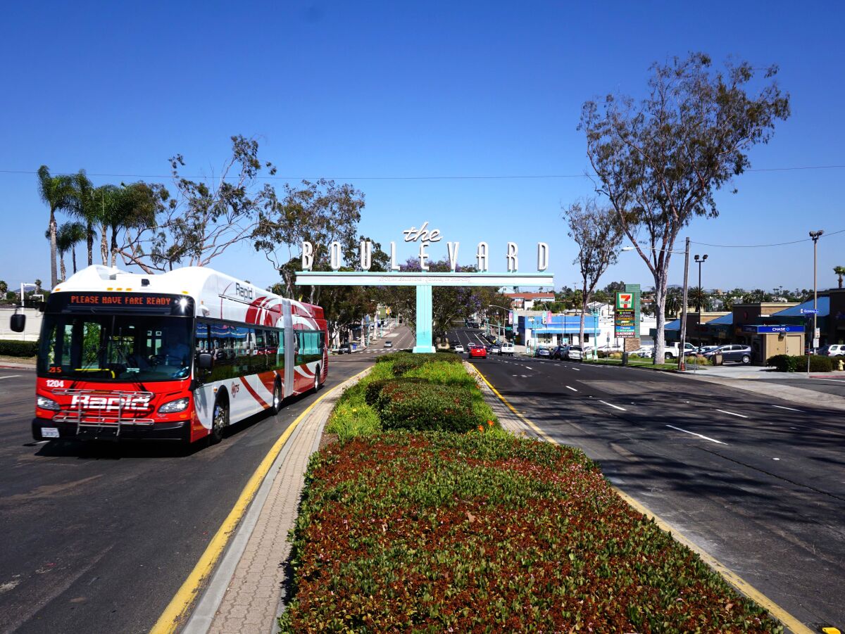 A bus drives near the Boulevard sign on El Cajon Boulevard