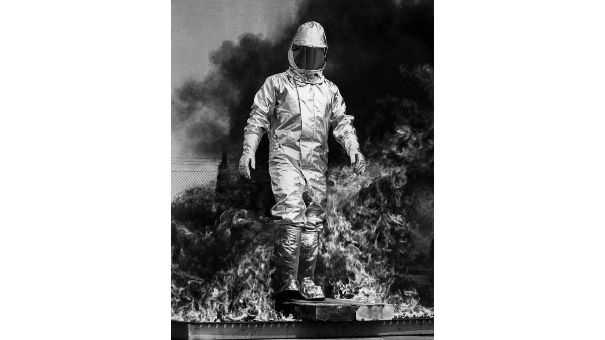 June 24, 1964: Test engineer John Hand ends walk through 3,000 degree gasoline fire in demonstration of new aluminized outfit for fire protection.