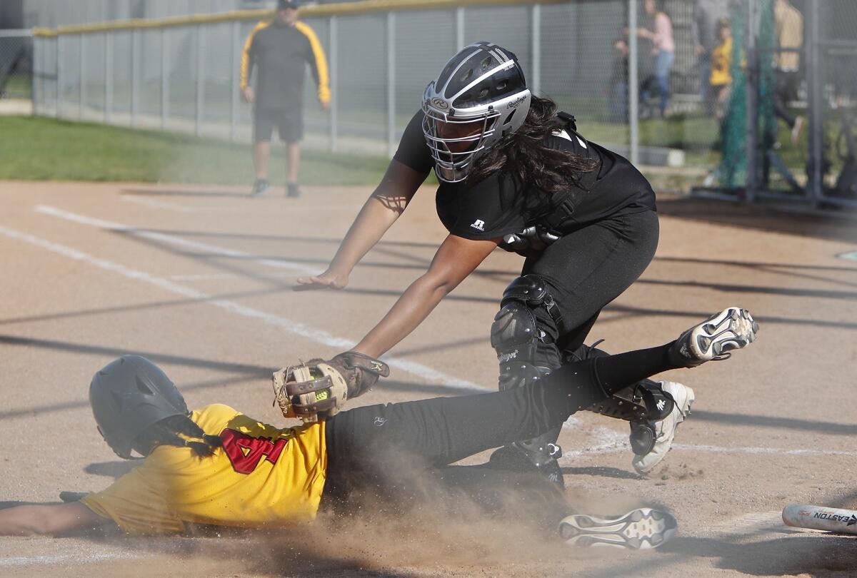 Costa Mesa High catcher Stephanie Herrera makes the tag on Estancia's Lena De La O in the third inning of an Orange Coast League game at Costa Mesa on Friday.