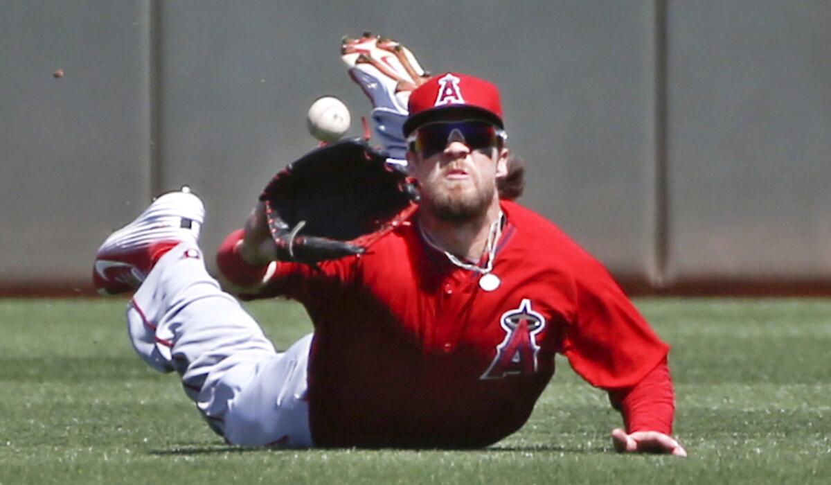 Angels center fielder Collin Cowgill makes a diving catch to rob Kansas City's Alcides Escobar of a hit in the first inning of a spring training game Saturday in Surprise, Ariz.