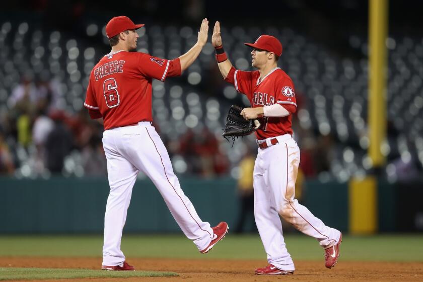 Angels outfielder Collin Cowgill, right, and third baseman David Freese, left, celebrate after a 9-3 win Tuesday over the Houston Astros at Angel Stadium.