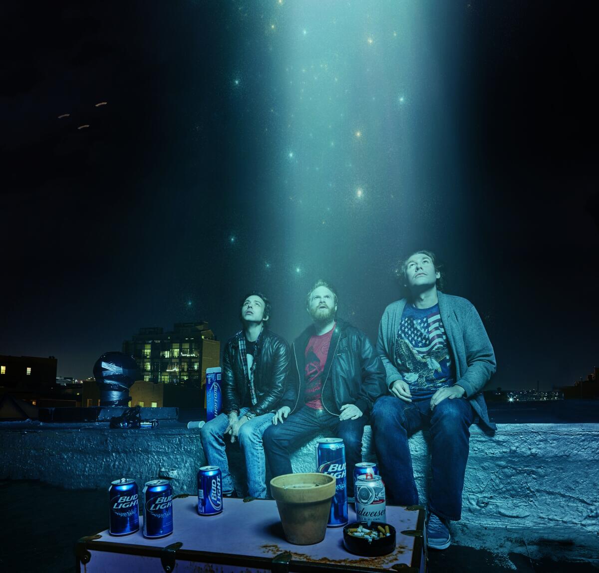 Three people look up into the sky as starlight shines down
