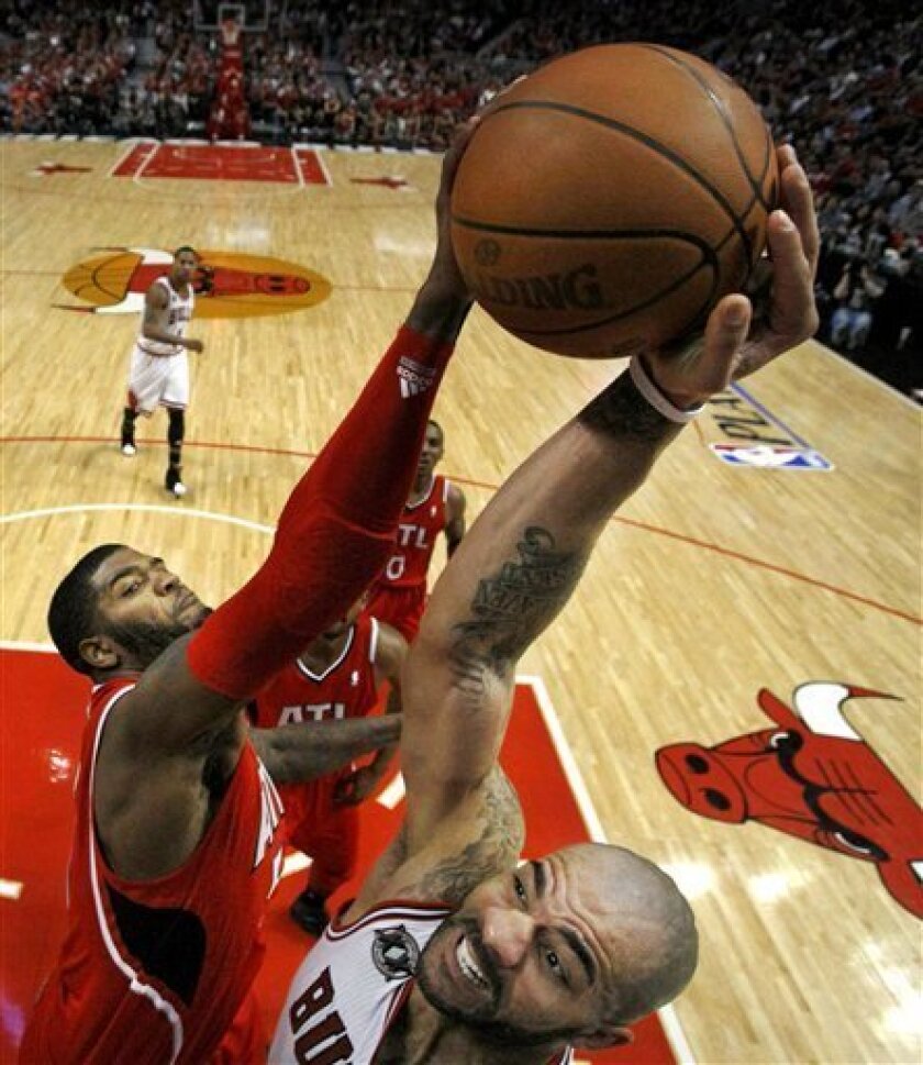 Atlanta Hawks power forward Josh Smith, left, blocks the shot of Chicago Bulls power forward Carlos Boozer during the third quarter in Game 2 of the NBA Eastern Conference semifinal series Wednesday, May 4, 2011, in Chicago. The Bulls won 86-73. (AP Photo/Charles Rex Arbogast)