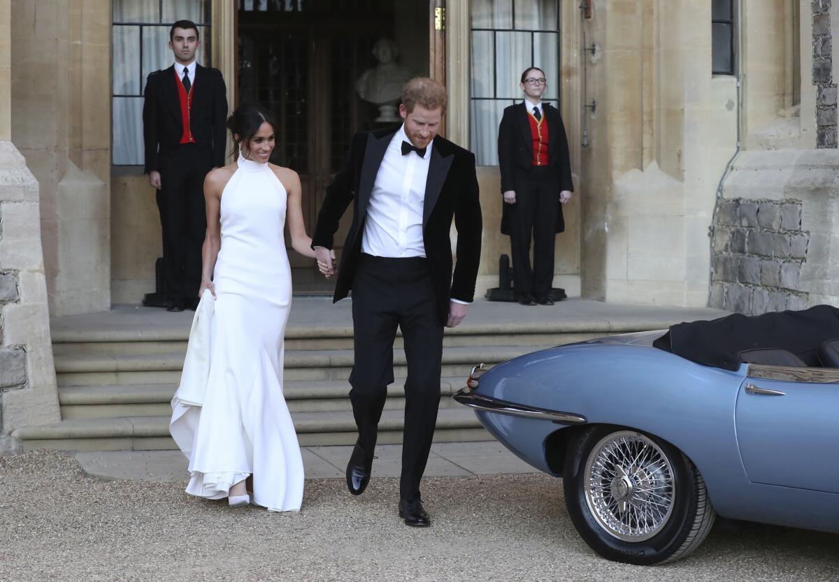 The newly married Duke and Duchess of Sussex, Prince Harry and Meghan Markle, leave Windsor Castle after their wedding in Windsor near London on Saturday to attend an evening reception at Frogmore House hosted by Harry's father, the Prince of Wales.