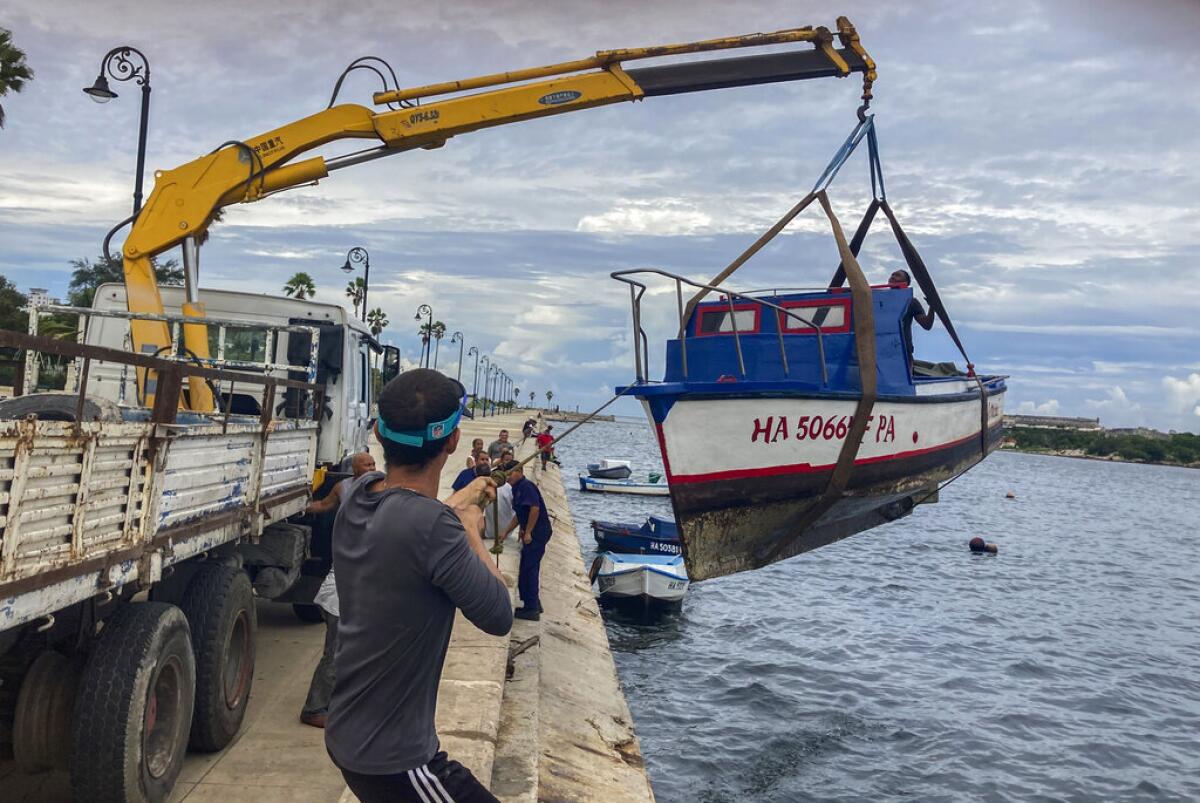 Trabajadores sacan un barco del agua en la bahía de La Habana