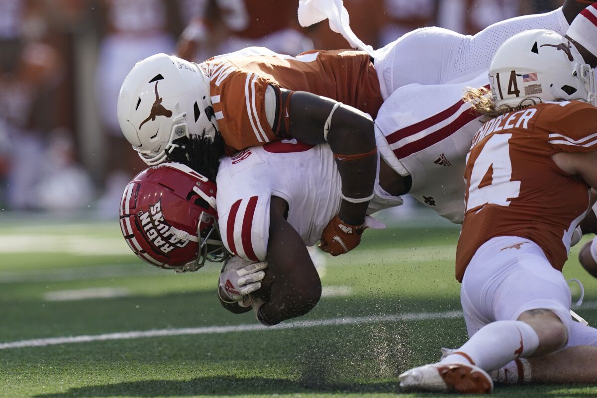 Louisiana-Lafayette running back Emani Bailey (9) is hit by Texas linebacker DeMarvion Overshown (0) during the second half of an NCAA college football game Saturday, Sept. 4, 2021, in Austin, Texas. (AP Photo/Eric Gay)