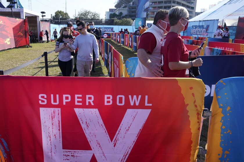 Fans arrive at Raymond James Stadium before the NFL Super Bowl 55 football game between the Kansas City Chiefs and Tampa Bay Buccaneers, Sunday, Feb. 7, 2021, in Tampa, Fla. (AP Photo/Gregory Bull)