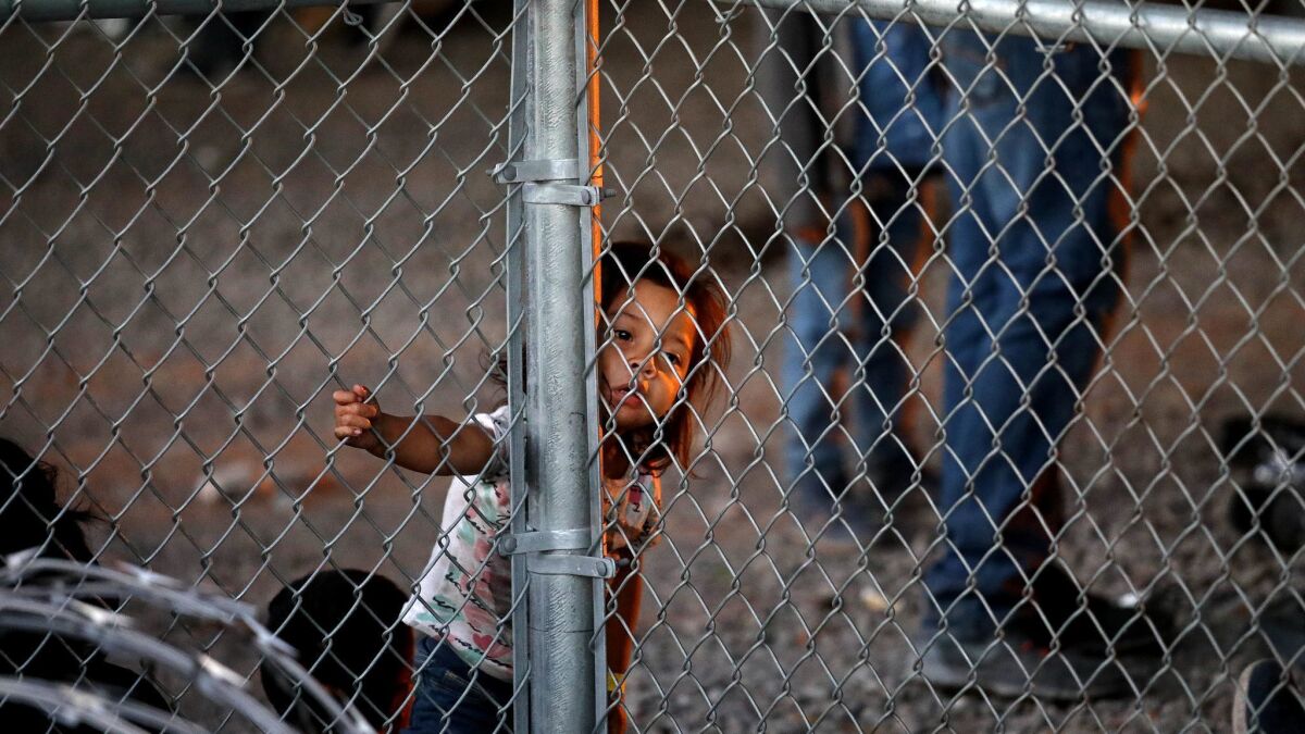 Hundreds of migrants seeking asylum are held in a pen under the Paso Del Norte bridge Thursday in El Paso.