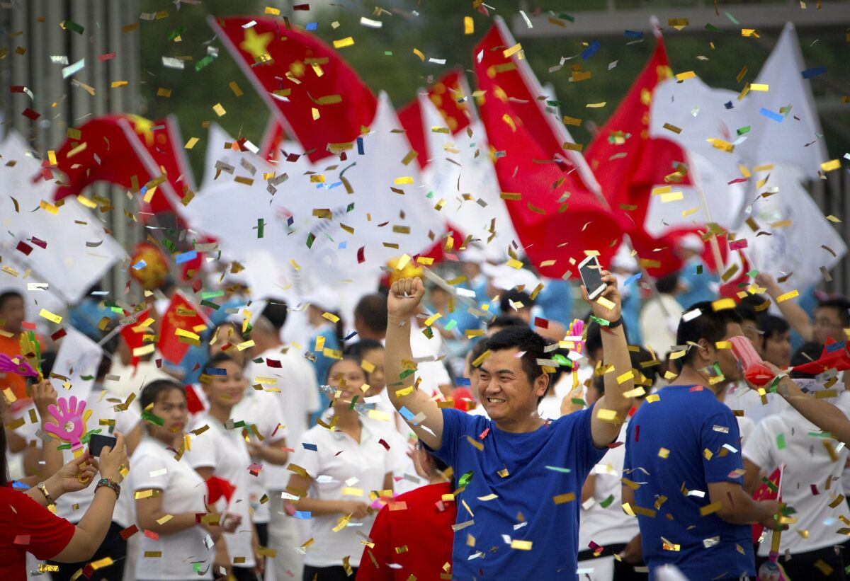 Chinese celebrate outside of the Beijing Olympic Stadium following an announcement Friday that Beijing will host the 2022 Winter Olympics.